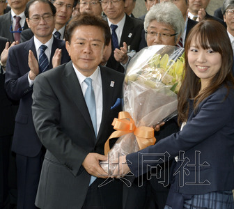 12月18日，高票當(dāng)選東京都新知事的豬瀨直樹正式到任。圖為豬瀨從政府職員手中接過花束。(共同社)