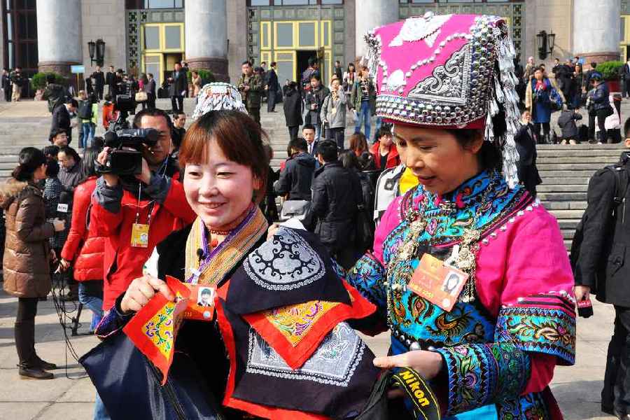 云南代表團(tuán)的兩位女代表在為記者展示她們帶來(lái)的民族特色手工藝品。 人民網(wǎng)記者 馬麗婭 攝