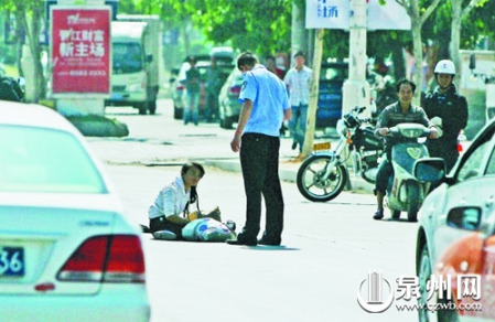 女孩從摩的上摔下，跌坐路中央，恰遇社區(qū)聯(lián)防巡邏人員扶起。