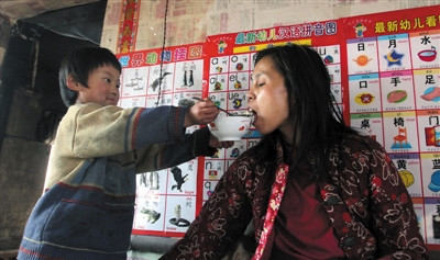 小孫悅為臥床的母親喂飯。