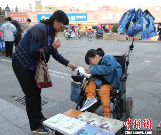 洛洛正在給買書的顧客簽名。 馮曉林 攝